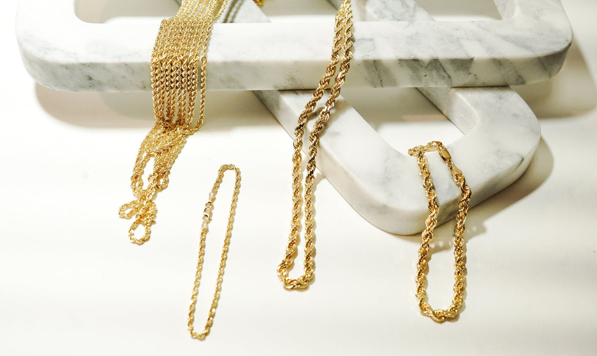 best solid gold chains for daily wear photographed on a white background using marble props