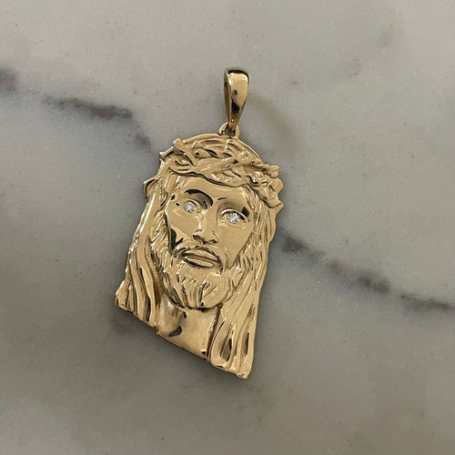 14k 18k 22k gold jesus piece custom made with diamonds laying flat