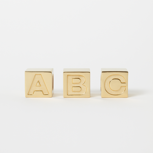 Three gold letter blocks spelling 'ABC' on a white background