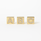Three gold blocks with diamond custom made 'A', 'B', and 'C' on a white background